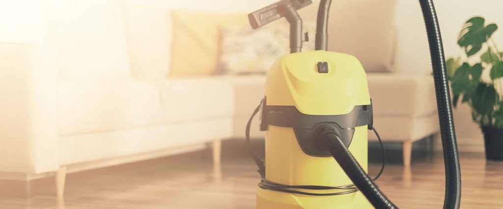 Aspirateur de chantier jaune dans un salon, prêt à l’emploi